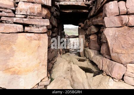 Der Eingang zu den Überresten von Clachtoll Broch (an Dun), die von Küstenerosion und Sturmschäden bedroht ist, Westküste von Assynt, NW Highland Stockfoto