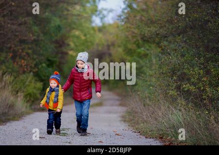 Glückliche Kinder, Laufen und Springen und Spielen im Herbstpark Stockfoto