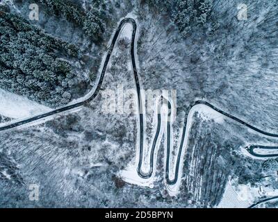 Jahreszeiten Konzept Winter verschneit Luftbild gewundene Straße Serpentin Bergpass Dorf Brodenbach Deutschland. Stockfoto