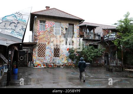 Touristen besuchen Metelkova Mesto in Ljubljana an einem nassen Tag Stockfoto