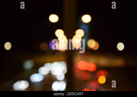 Verwackelte Ampeln in der Nacht. Verschwommene Lichter der Stadt in der Nacht. Bokeh-Lichter bei Nacht in München. Stockfoto