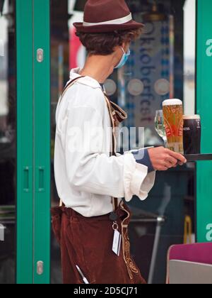 Das in germanischer Mode gekleidete Personal serviert Getränke am Brighton Pier Vor einem riesigen Fernsehbildschirm Stockfoto