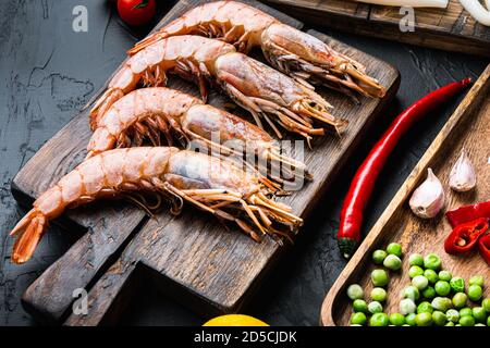 Set von Garnelen mit Zutaten für Paella auf schwarz Strukturierter Hintergrund Stockfoto