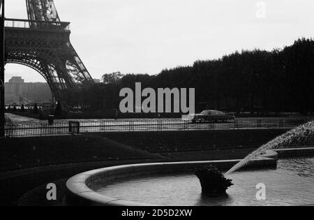 CADILLAC ELDORADO PARKTE VOR DEM EIFFELTURM IN CHAMPS DE MARS AM FRÜHEN MORGEN PARIS FRANKREICH - PARIS AUTO - PARIS STRASSENFOTOGRAFIE - SCHWARZ-WEISS SILBER FILM © FREDERIC BEAUMONT Stockfoto