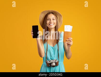 Frau im Sommer Hut mit Pass zeigt Smartphone leeren Bildschirm Stockfoto