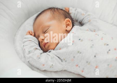 Obere Ansicht Foto eines kaukasischen Neugeborenen, das darin schläft Weiße Kleidung zu Hause Stockfoto