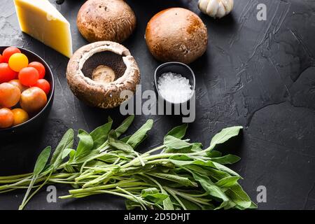 Garlicky Portabello Pilze Zutaten zum Backen, Cheddar-Käse und Salbei auf schwarzem Hintergrund. Seitenansicht. Leerzeichen für Text. Stockfoto