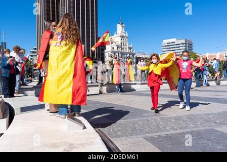 Madrid, Spanien, 12. oktober 2020. Kinder tanzen mit Flaggen während eines Protestes gegen die Behandlung der COVID-19-Krise durch die spanische Regierung. Stockfoto