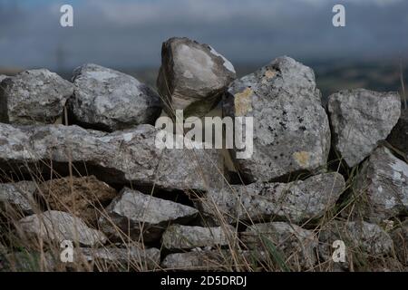 Nahaufnahme einer traditionellen Felswand aus trockenem Stein, die eine Farmers Field-Grenze trennt. Stockfoto