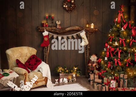 Auf einem Holzkamin aus alten Baumstämmen, gibt es eine Strecke von Fahnen mit der Aufschrift Magie, weiß-rote Socken für Weihnachtsmann Geschenke Weihnachten Stockfoto