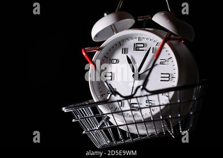 Roter Warenkorb mit weißem Retro-Wecker darin. Verlieren Sie Zeit. Kaufzeit. Pause. Motivation. Geschäftslösungen. Erfolg. Frist. Stockfoto