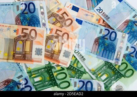 Verschiedene Euro-Banknoten sind auf einer Ebenen Oberfläche in verschiedenen Stückelungen und Farben verteilt Stockfoto