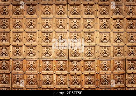 Nahaufnahme einer alten bestückten Holztür mit quadratischen und kreisförmigen Formen, voller Rahmen. Verona Innenstadt, Venetien, Italien, Europa Stockfoto