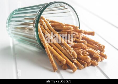 Salzige Sticks. Knusprige Brezeln aus Glas auf weißem Tisch. Stockfoto