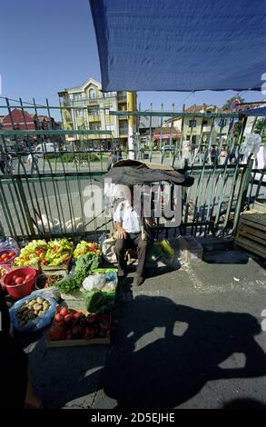 EIN ALTER MANN, DER GEMÜSE AUF DEM MARKT VON KRUSEVAC VERKAUFT SERBIEN - STRASSENFOTOGRAFIE - FARBE SILBER FILM © F.BEAUMONT Stockfoto