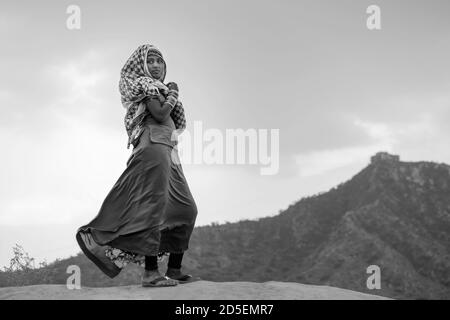 Junge Zigeunerin in traditioneller Kleidung, die einen Teil ihres Gesichts in der Thar-Wüste im Morgengrauen in Pushkar, Rajasthan, Indien bedeckt. Stockfoto