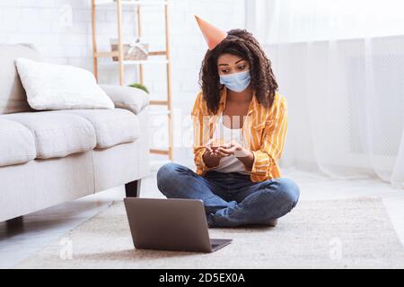 Schwarze Frau in Party Hut Geburtstag feiern online Stockfoto
