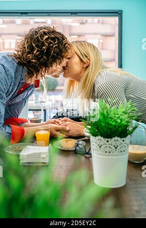 Paar küssen in einem Café Stockfoto