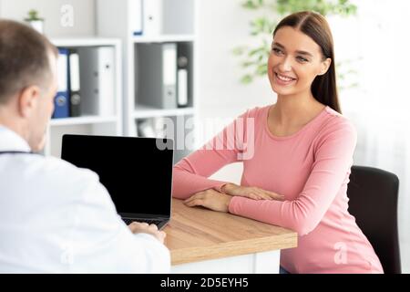 Männlicher erfahrener Arzt im Gespräch mit weiblicher Patientin Stockfoto