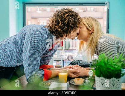 Paar küssen in einem Café Stockfoto