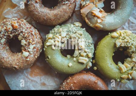 Frisch gebackene Krapfen in flacher Lage auf Holzplatte.Milchkrapfen Mit Nüssen im Café für die Mittagspause serviert.Genießen Sie leckere holländische Donut mit Kaffee für Lunc Stockfoto