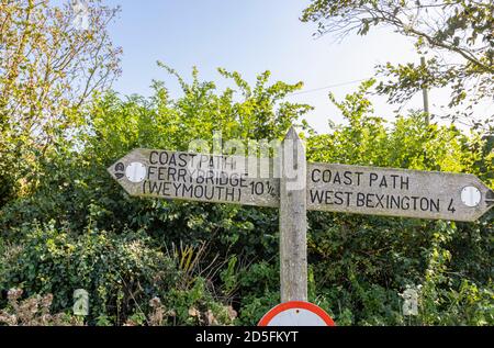 Typisches hölzerner Wegweiser nach Ferrybridge und West Bexington auf dem South West Coast Path an der Heritage Coast in der Nähe von Abbotsbury, Dorset Stockfoto