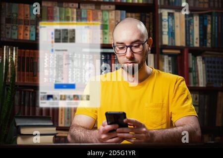 Soziale Netzwerke. Ein kahler Mann mit Brille benutzt ein Smartphone. Digitales klares Fenster über dem Telefon. Im Hintergrund befinden sich Bücherregale. Der Nachteil Stockfoto