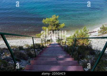 Eine Treppe zum Meer auf den Felsen führt zu einem wilden Strand. Straße durch den Wald und Camping. Der Stadtrand von Gelendzhik. Russland Stockfoto