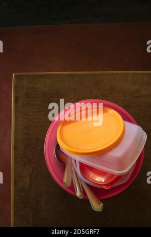 Bolpur, Westbengalen/Indien - 10.10.2020: Lebendige Lunchboxen mit Stahllöffeln - Draufsicht, Nahaufnahme. Plastifizierware und Haushaltsgeräte. Stockfoto