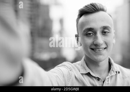Junger stattlicher Mann mit blonden Haaren gegen den Blick auf die Stadt Stockfoto