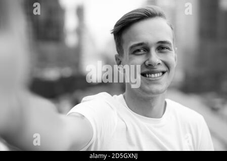 Junger stattlicher Mann mit blonden Haaren gegen den Blick auf die Stadt Stockfoto