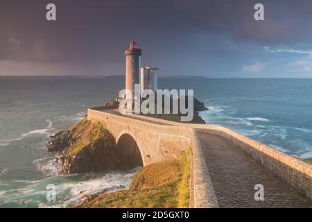 Leuchtturm in Europa bei stürmischem Wetter. Petit Minou Leuchtturm bei Sonnenuntergang mit rotem Licht, Brest , Frankreich Blick auf Leuchtturm von Petit Minou Stockfoto