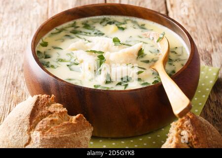 Cullen skink ist eine dicke schottische Suppe aus geräuchertem Schellfisch, Kartoffeln und Zwiebeln, die in der Nähe auf dem Teller auf dem Tisch liegen. Horizontal Stockfoto