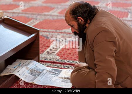 Damaskus, Syrien, 03/28/2010: Ein bärtiger arabischer Mann mittleren Alters sitzt mit gekreuzten Beinen auf dem Teppichboden der Umayyad-Moschee (große Moschee) in Damascu Stockfoto