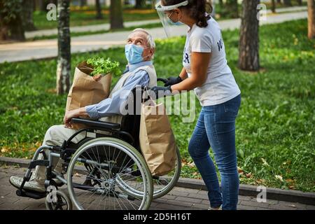 Erwachsene Frau, die mit einem älteren Mann im Park läuft Stockfoto