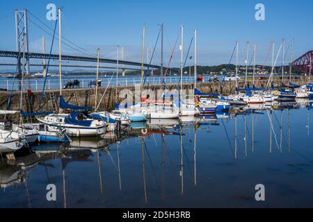 Bunte Yachten liegen im geschützten Hafen von South Queensferry vor der Kulisse der Queensferry Crossing Road Bridge - South Queensferry, Schottland, Großbritannien Stockfoto