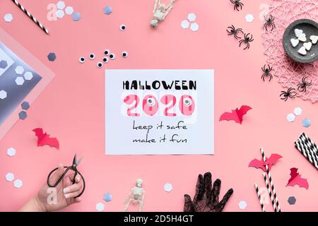 Rosa Papier Hintergrund mit Halloween-Dekor. Halloween 2020 Keep it Safe, machen es Spaß Text auf Papier. Stockfoto