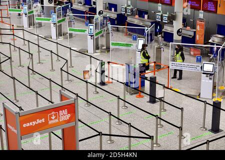 Leere Abflüge am Flughafen mit sozialer Distanz, Personal, aber keine Passagiere Stockfoto