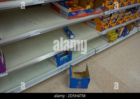 Leere Regale, da Kunden Grundwaren aufgrund der Coronavirus-Epidemie in einem Tesco-Supermarkt in London, England, Großbritannien, laden Stockfoto