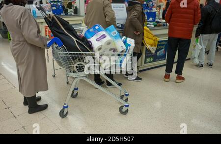 In einem Tesco-Supermarkt in London, England, Großbritannien, laden Kunden Toilettenpapier und Grundwaren aufgrund der Coronavirus-Epidemie Stockfoto