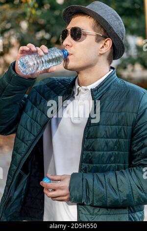 Nahaufnahme von einem Mann Wasser aus einer Flasche außerhalb Stockfoto