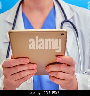Krankenschwester nutzte mobiles Internet, um Patienten online zu helfen. Arzt hält eine digitale Tablette, Nahaufnahme. Konzept zur Unterstützung von Patienten mit Coronovirus online. Stockfoto