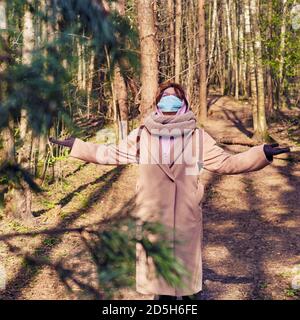 Die Frau im Park freut sich im Frühling und am Ende Isolation durch Coronavirus Stockfoto