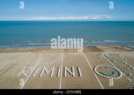 Rimini Strand von Drohne und RIMINI geschrieben mit Sonnenschirmen Stockfoto