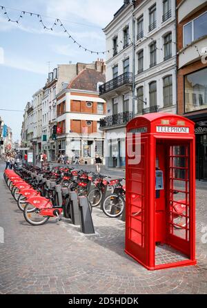 LILLE, FRANKREICH - 18. Juli 2013. Kostenloser Fahrradverleih und rote britische Telefonbox in einer Straße in Lille, Frankreich Stockfoto