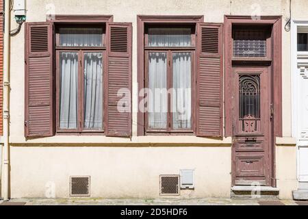 LILLE, FRANKREICH - 19. Juli 2013. Außerhalb eines alten französischen Hauses mit Holztüren und Fenstern mit braun lackierten Fensterläden Stockfoto