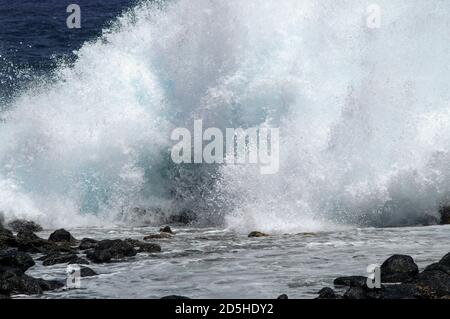 Eine riesige Welle stürzt gegen die Felsen. Felsige Uferlinie. Stockfoto