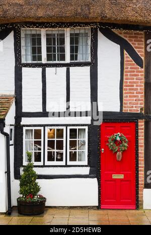 WINSLOW, Großbritannien - 26. Dezember 2019. Weihnachtsdekorationen außerhalb des alten reetgedeckten Cottage House in Großbritannien, Winter Street Szene Stockfoto