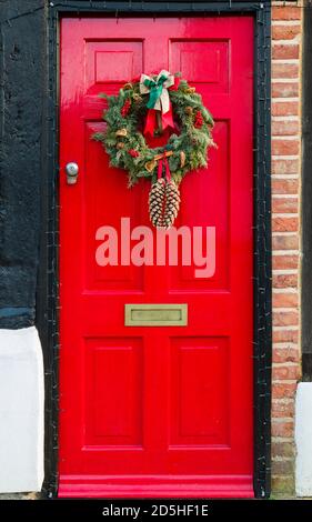 WINSLOW, Großbritannien - 29. Dezember 2019. Rote Haustür von Großbritannien zu Weihnachten mit einem Weihnachtskranz Ornament Stockfoto