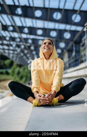 Schöne aktive Dame in Sportkleidung auf Treppen sitzen Stockfoto